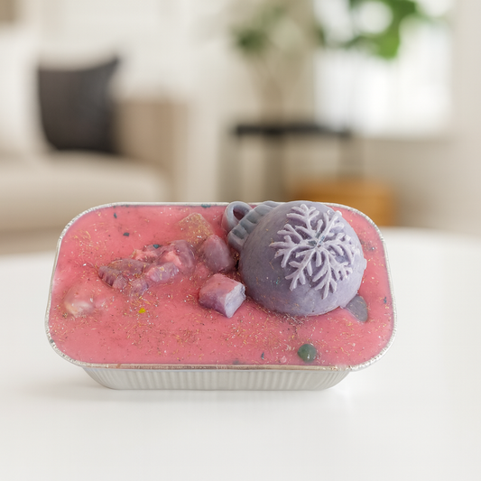 Pink and purple wax cake with a blurred indoor background