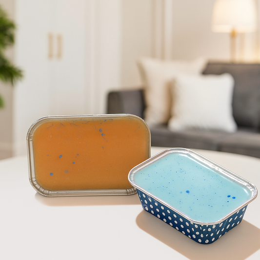 Two wax melts containers, one orange and one blue with white polka dots, on a table in a living room setting.
