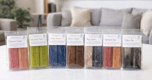 Set of wax bars in clear packaging on a white surface with a blurred living room background