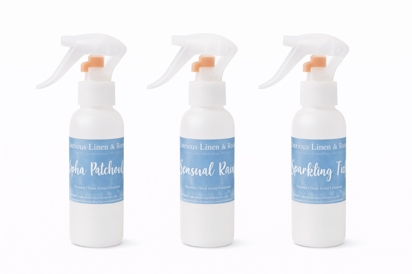 Three white spray room and linen spray bottles with blue labels on a white background